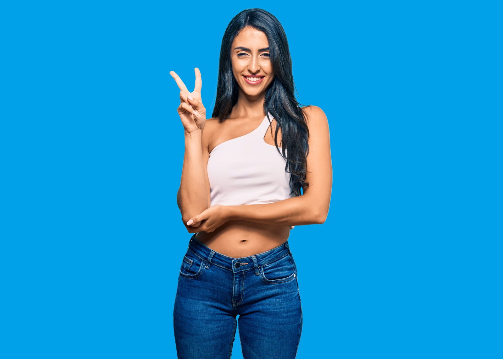 Beautiful hispanic woman wearing casual clothes smiling with happy face winking at the camera doing victory sign with fingers. number two.